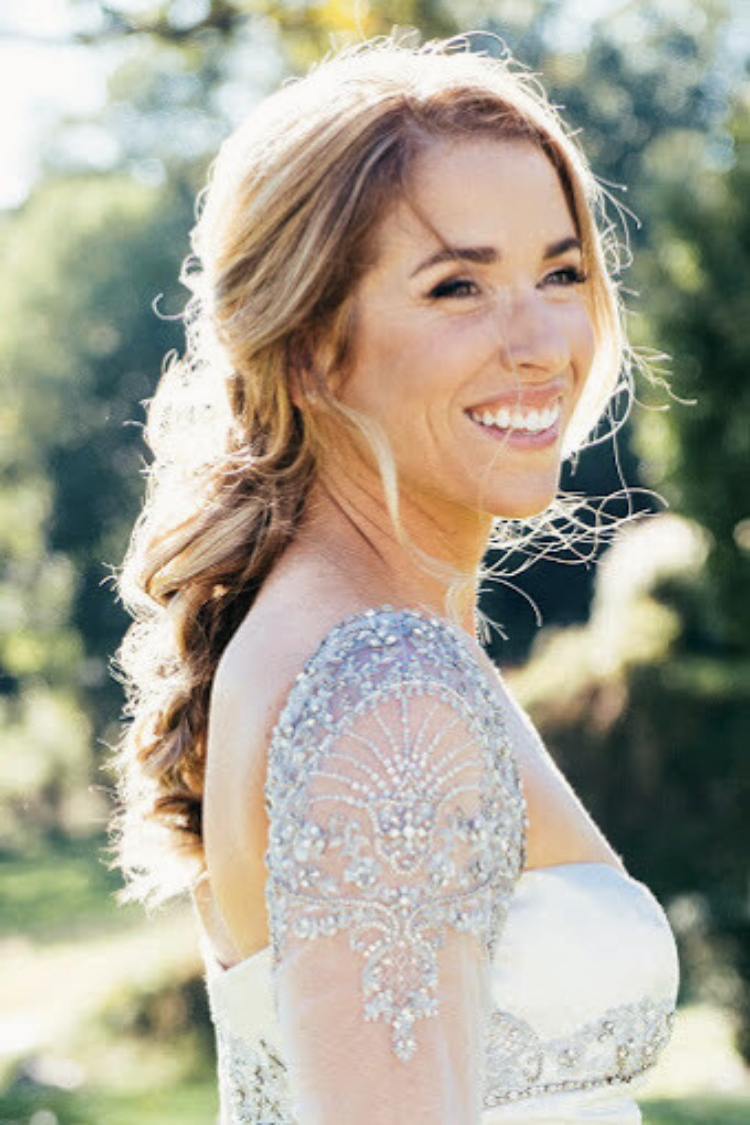 Radiant bride wearing natural bridal makeup by AD Artistry, showing off her elegant wedding hairstyle